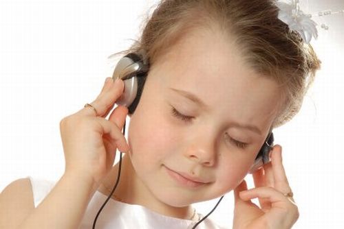 Bambina con le cuffie che ascolta beata a volume basso